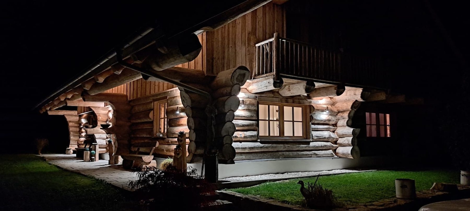 Beleuchtete Blockhaus-Fassade am Abend