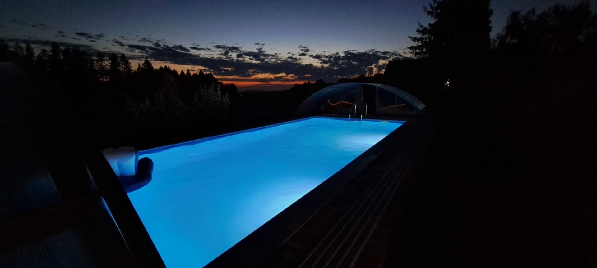 Beleuchteter Pool in der Abenddämmerung